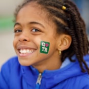 GOTR participant smiles with a green GOTR tattoo on her cheek!